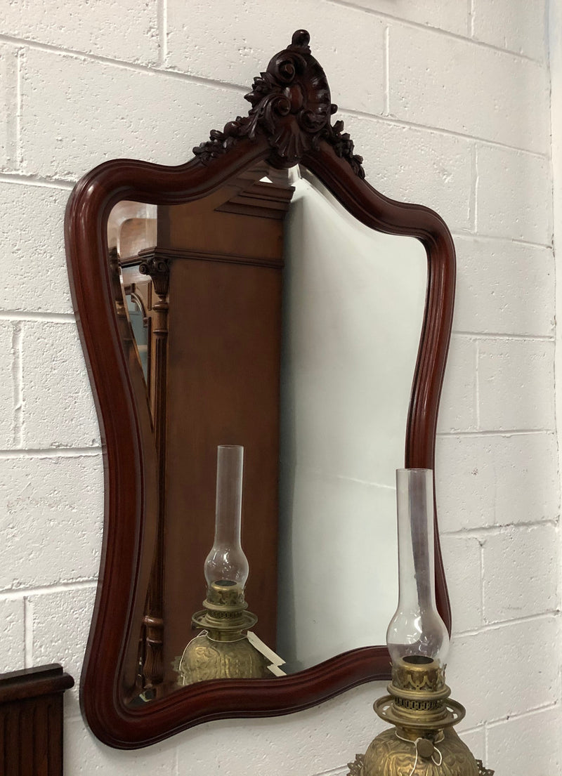 Lovely French mahogany wall mirror with carved detail, beveled glass and in good condition.