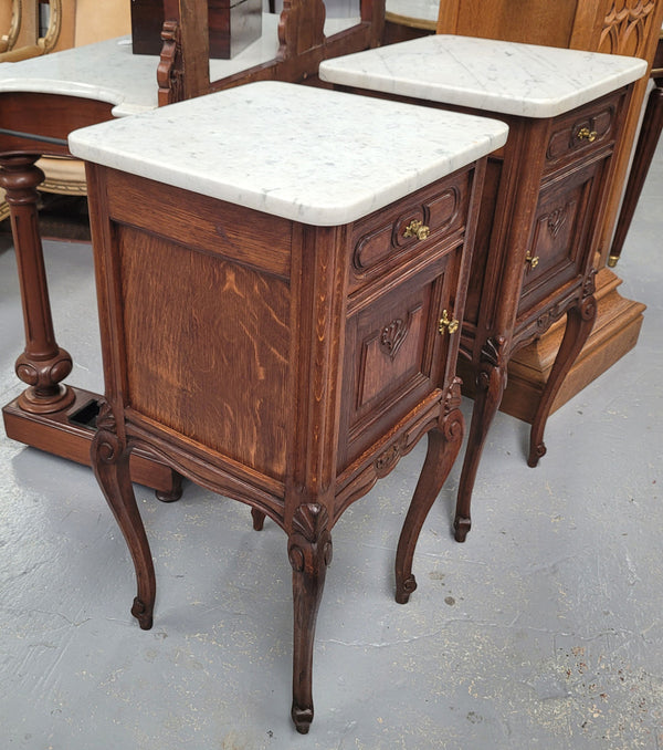 Pair French oak Louis XV style white carrera marble top bedside cabinets. Consisting of one drawer and one cupboard each on elegant legs. Circa: 1900's