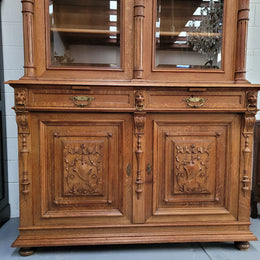 Amazing French 19th Century Oak two-door bookcase. Amazing detailed carvings throughout and plenty of storage space with three adjustable shelves at the top, two drawers, and a further shelf at the bottom. Also has two pull out reading slides giving you a large area to view your books on. In very good original detailed condition.