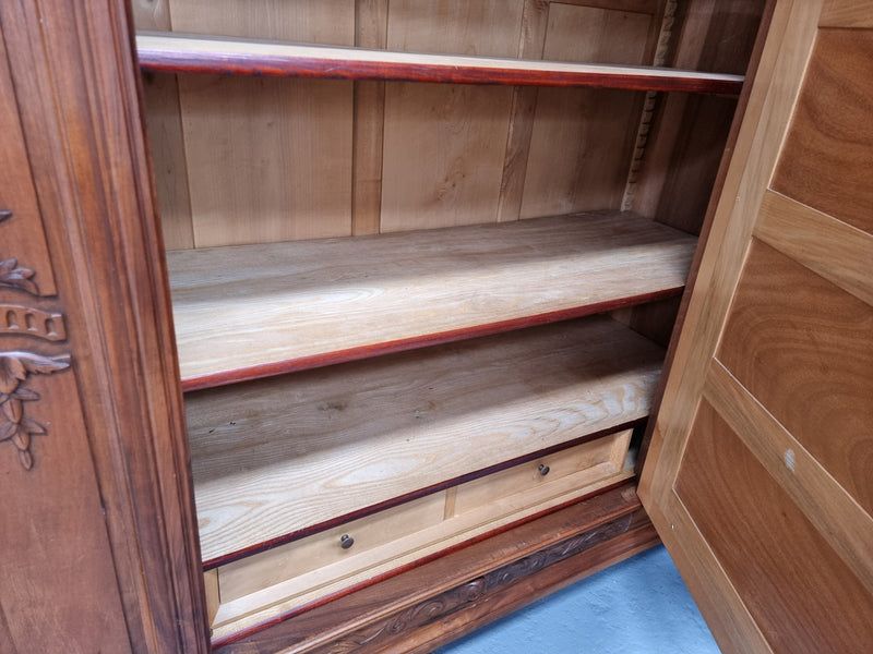 Imposing Louis XV style single mirrored door Walnut armoire. Features deep carved decoration, two interior drawers and three adjustable shelves. It is in good original detailed condition and has been sourced from France.