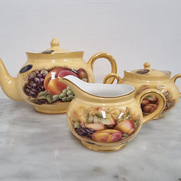 “Aynsley Orchard Gold” tea set on tray. Consisting of small teapot, lidded sugar and creamer. Please view photos as they help form part of the description.