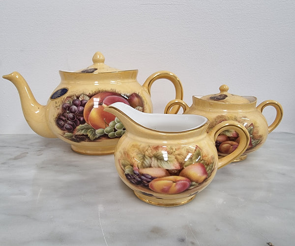 “Aynsley Orchard Gold” tea set on tray. Consisting of small teapot, lidded sugar and creamer. Please view photos as they help form part of the description.