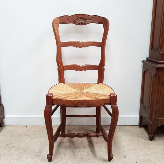 A set of six French Louis XV style, ladder back oak chairs. With finely carved detail and rush seat. In great original condition. Chairs are comfortable and sturdy for everyday use.