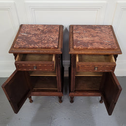 Pair of French Art Deco Oak and rouge inset marble top bedside cabinets. They have one drawer and one cupboard with elegant carving on the door. They have been sourced from France and are in good original detailed condition.