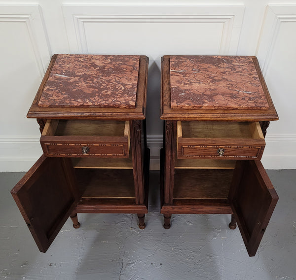 Pair of French Art Deco Oak and rouge inset marble top bedside cabinets. They have one drawer and one cupboard with elegant carving on the door. They have been sourced from France and are in good original detailed condition.