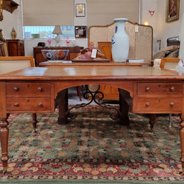 English Cedar full partners desk with attractive tooled leather top, four drawers either side and on caster wheels.  In good original detailed condition.