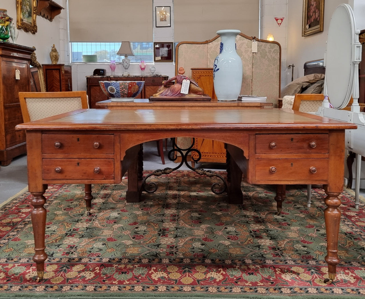 English Cedar full partners desk with attractive tooled leather top, four drawers either side and on caster wheels.  In good original detailed condition.