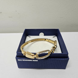 Swarovski gold toned fitted bangle set with Swarovski crystals. Swarovski mark to band, and a side opening. Charming little bracelet. Please see photos as they form part of the description.