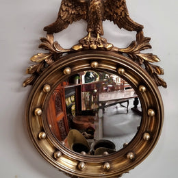 Vintage gilt framed convex mirror featuring carved eagle. It has been sourced from France and is in good original condition, please view photos as they help form part of the description.