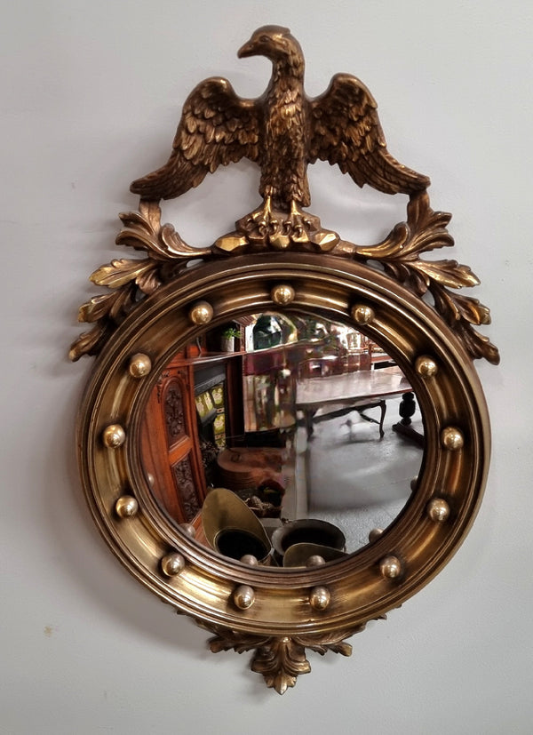 Vintage gilt framed convex mirror featuring carved eagle. It has been sourced from France and is in good original condition, please view photos as they help form part of the description.