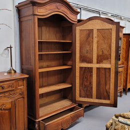 French Louis XV style Walnut armoire with single bevelled mirrored door. It has four adjustable shelves and a hidden exterior drawer at the bottom. It has been sourced from France and is in good original detailed condition.
