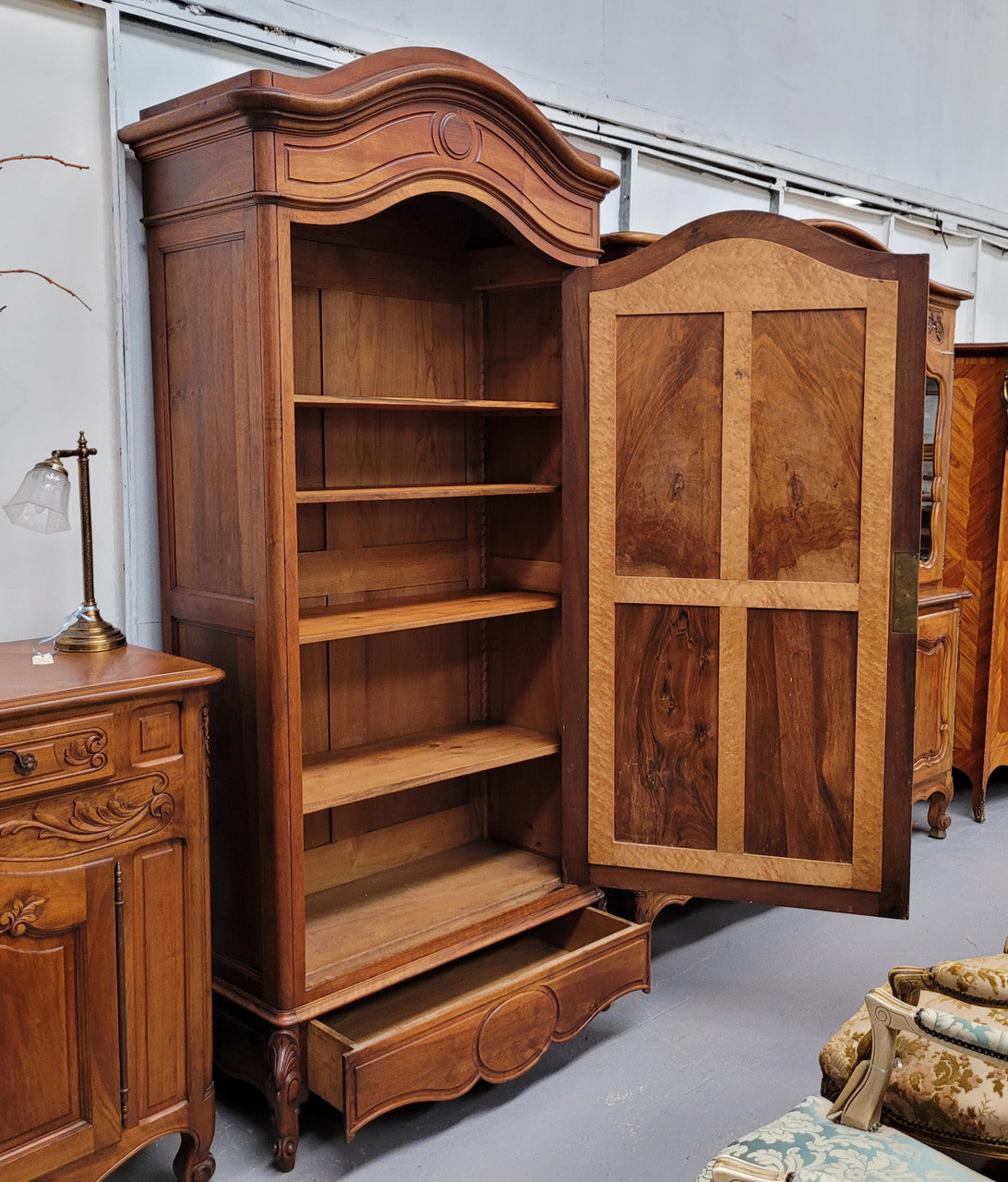 French Louis XV style Walnut armoire with single bevelled mirrored door. It has four adjustable shelves and a hidden exterior drawer at the bottom. It has been sourced from France and is in good original detailed condition.