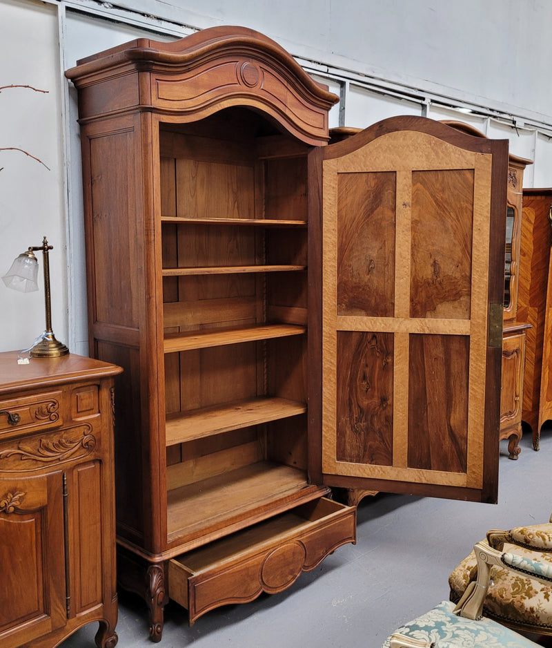 French Louis XV style Walnut armoire with single bevelled mirrored door. It has four adjustable shelves and a hidden exterior drawer at the bottom. It has been sourced from France and is in good original detailed condition.