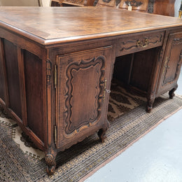 Fabulous Louis XV style French Oak beautifully carved full partners desk. Both sides have a functioning drawer in the middle and two cupboards either side. On both sides one cupboard door opens up to four smaller internal drawers. Plenty of storage space and a large top surface to work on. It is in good original detailed condition.