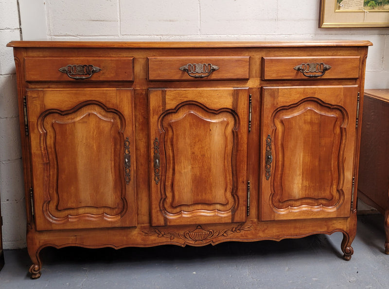 Beautiful French three door three drawer Louis XV style Cherrywood sideboard. It has a total of four adjustable shelves and comes with three keys. It has been sourced from France and is in good original detailed condition.