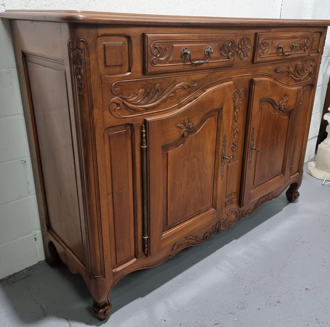French Walnut two door buffet with parquetry top. It has two drawers and an adjustable shelf. In good original detailed condition and it has been sourced from France.