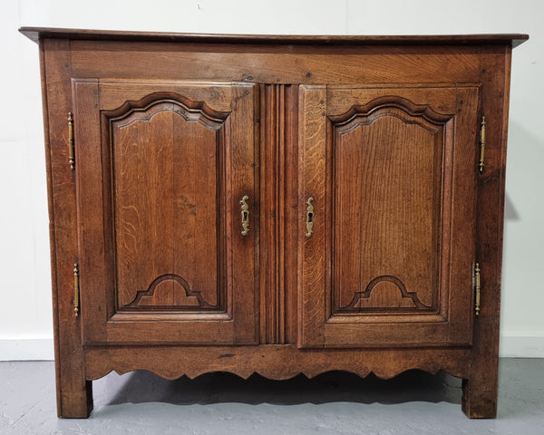 A charming French Oak early 18th Century two door sideboard. Plenty of storage space with two fixed shelves either side. It is in good original detailed condition for its age and comes with  a working key and working locks.