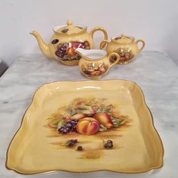 “Aynsley Orchard Gold” tea set on tray. Consisting of small teapot, lidded sugar and creamer. Please view photos as they help form part of the description.