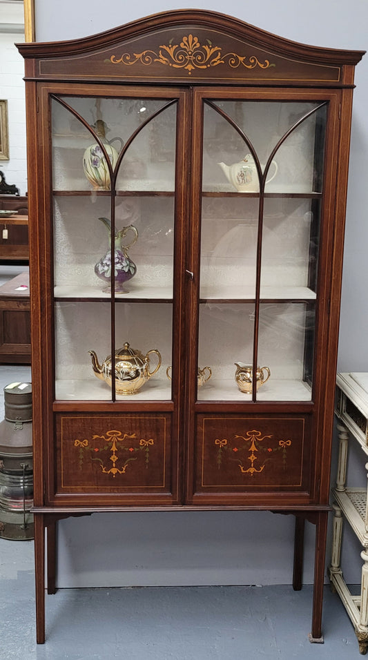 Edwardian Sheraton style display cabinet with hand-painted panels and a good fabric interior. In good original detailed condition.