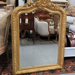Beautiful French Napoleon III Louis XV style gilt framed bevelled mirror with an ornate crest on top. It has been sourced from France and is in good original detailed condition with the mirror showing signs of age.