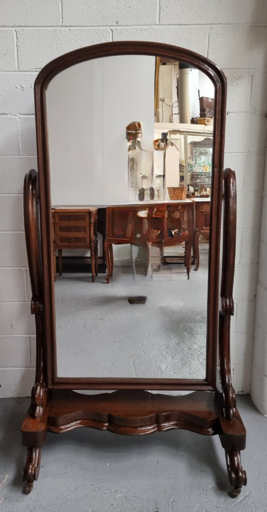 Antique Victorian 19th Century full length Mahogany cheval mirror. Mirror supported on two elegant scrolled upright support and stands on moulded base with four scrolled feet and castors.