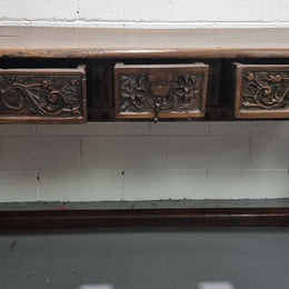 Rare and Charming 17th Century Spanish Walnut serving / side table. It has an incredible one piece walnut top with amazing character and colour. The base displays the original patina aswell as three drawers with carving and remnants of original locks. Superbly turned legs terminating on a stretcher base. Could be used as a large entrance console table, a side table or in a dining area as a serving table. In good original detailed condition especially considering its age.