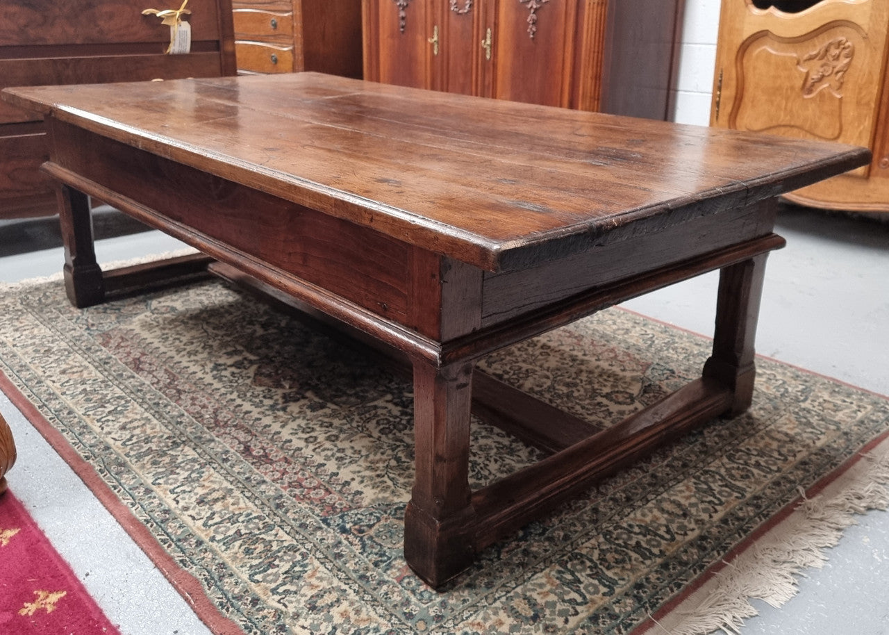 Impressive large size rustic French Oak coffee table with two drawers on a stretcher base. In good original detailed condition and sourced from France.