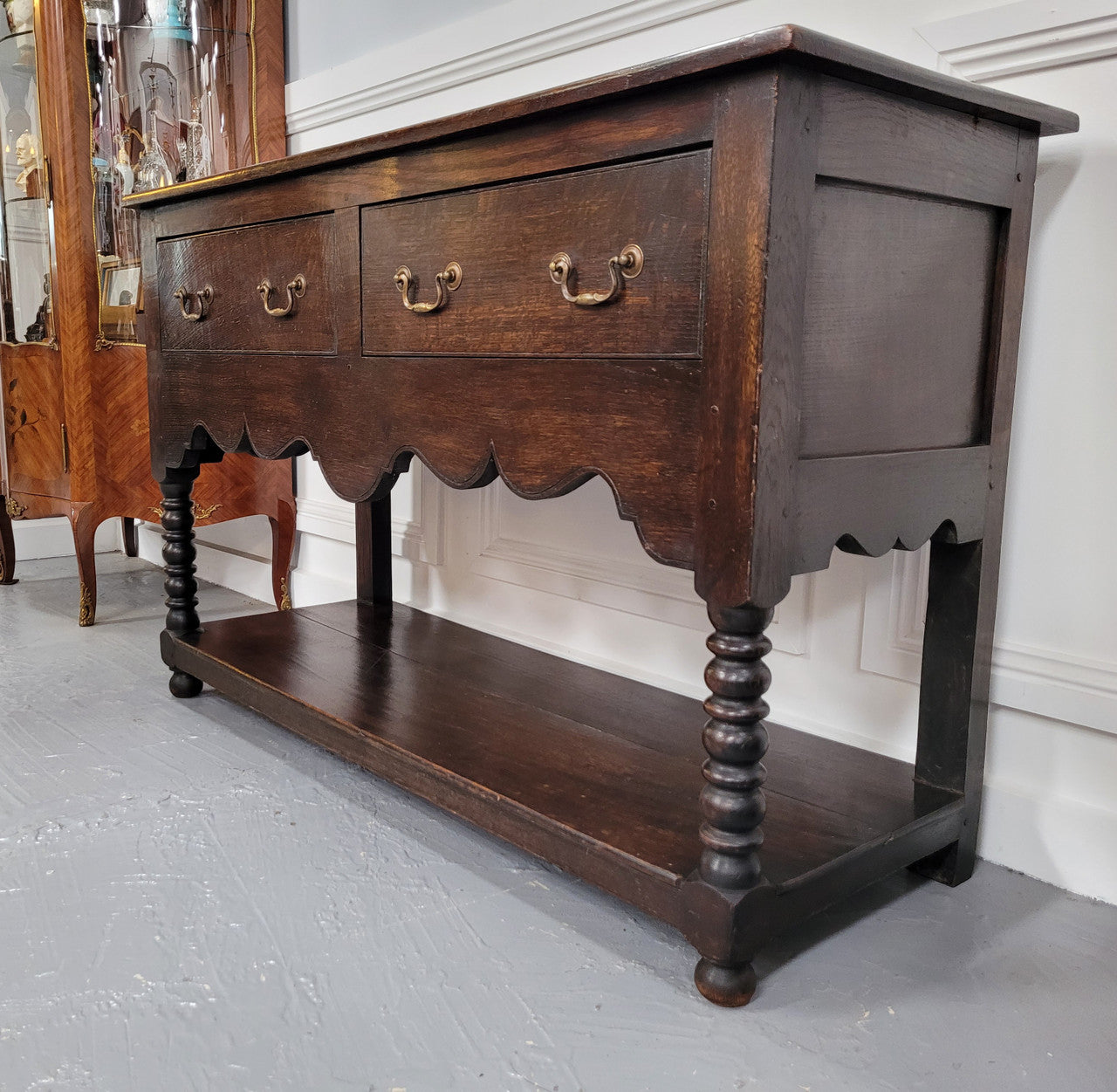 Rare size 19th Century English oak dresser base. It has two good size drawers and amazing patina. It has been sourced from France and in good original detailed condition.