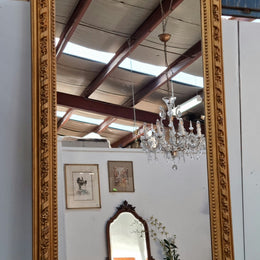Grand French 19th Century Napoleon III style gilt mantle mirror. Frame has detailed acanthus leaf carving patterns and a beautiful ornate crest on top. In good original condition.