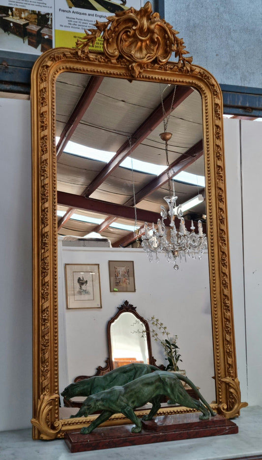 Grand French 19th Century Napoleon III style gilt mantle mirror. Frame has detailed acanthus leaf carving patterns and a beautiful ornate crest on top. In good original condition.