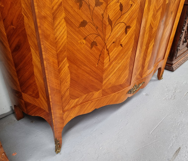 Charming French Louis XV Style Marquetry Inlaid Two Door Armoire. Features three adjustable shelves and ormolu trim. It has been sourced from France and is in good original condition.