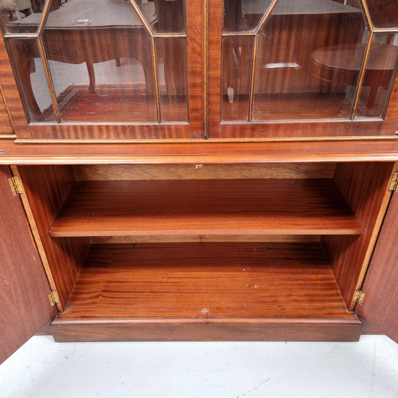 Georgian style Breakfront Flame Mahogany four door bookcase. A very impressive piece with plenty of storage and is of pleasing narrow proportions. It has been sourced locally and is in good original detailed condition.