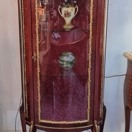 French Mahogany two shelf vitrine with curved glass and brass mounts. It has a lovely frabic interior and two glass shelves. In good original detailed condition.