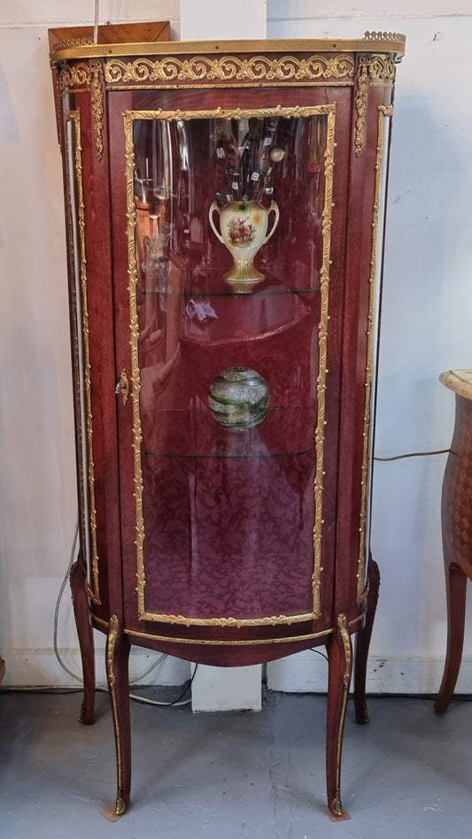 French Mahogany two shelf vitrine with curved glass and brass mounts. It has a lovely frabic interior and two glass shelves. In good original detailed condition.
