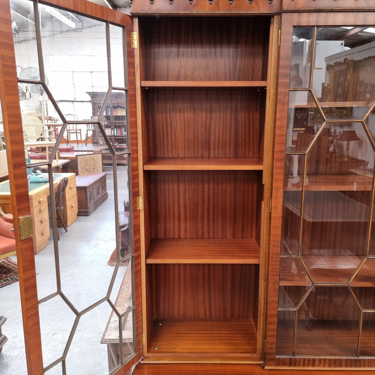 Georgian style Breakfront Flame Mahogany four door bookcase. A very impressive piece with plenty of storage and is of pleasing narrow proportions. It has been sourced locally and is in good original detailed condition.