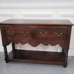 Rare size 19th Century English oak dresser base. It has two good size drawers and amazing patina. It has been sourced from France and in good original detailed condition.