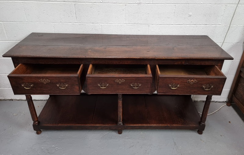 Antique 19th Century English dark Oak three drawer Dresser with brass handles and in good original condition.