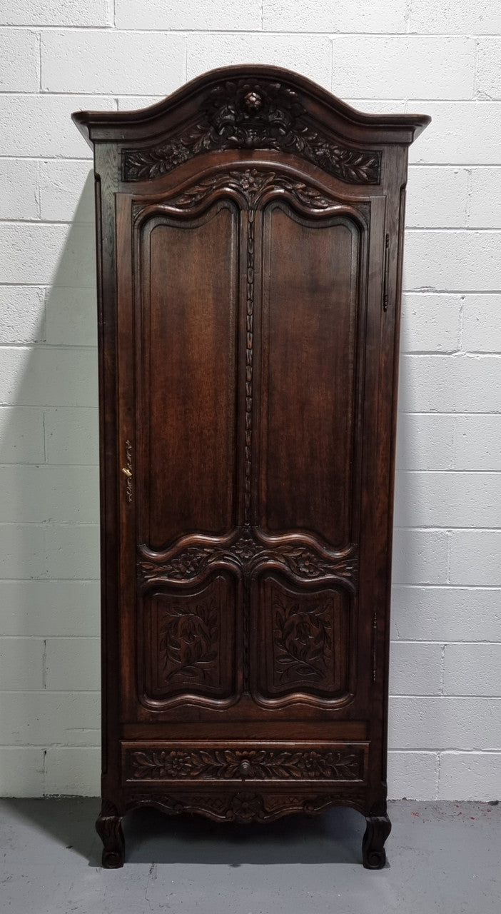 An Attractive French Louis XV style single-door ‘Marriage Armoire’. Beautifully arched crest with detailed carved flowers along with an arched single door which repeats the floral carvings. It is also has plenty of storage space with three adjustable shelves along with a drawer at the bottom. All in good original detailed condition.