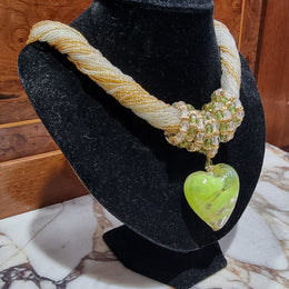 Hand Made Murano glass multi string small glass beads with medium glass beads and a large puff heart in neutral and green shades with gold. In original box.