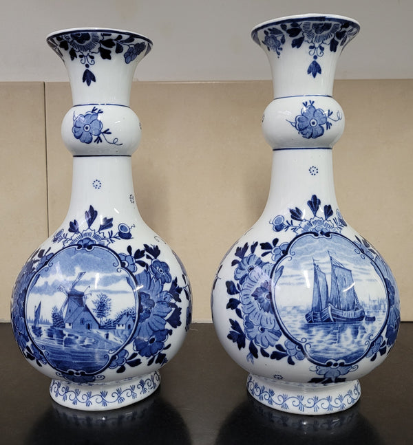 Pair of Victorian delft blue hand painted vases. Stamped underneath and one featuring a ship scene and the other a windmill scene. Please note the windmill vase does have a hairline crack at the top otherwise in good condition, please view photos as they help form part of the description.