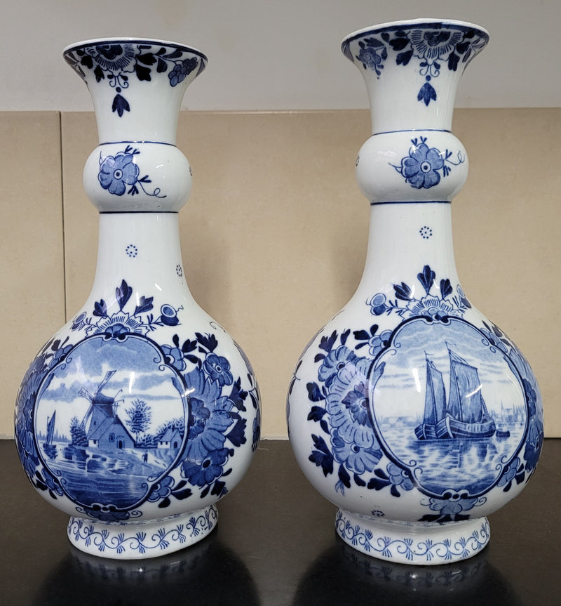 Pair of Victorian delft blue hand painted vases. Stamped underneath and one featuring a ship scene and the other a windmill scene. Please note the windmill vase does have a hairline crack at the top otherwise in good condition, please view photos as they help form part of the description.