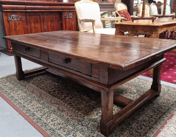 Impressive large size rustic French Oak coffee table with two drawers on a stretcher base. In good original detailed condition and sourced from France.