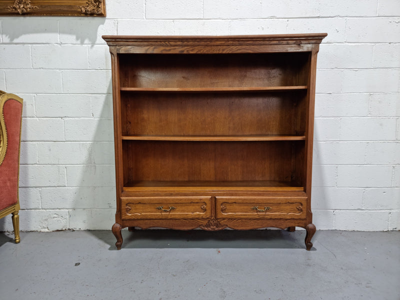 Lovely French Oak Louis XV style open shelf bookcase with two drawers for storage and three shelves in good original detailed condition.