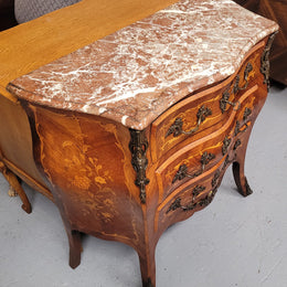 Antique French Louis XV style compact three drawer marble top commode with marquetry inlay and ormolu mounts. Sourced from France and in good original detailed condition.