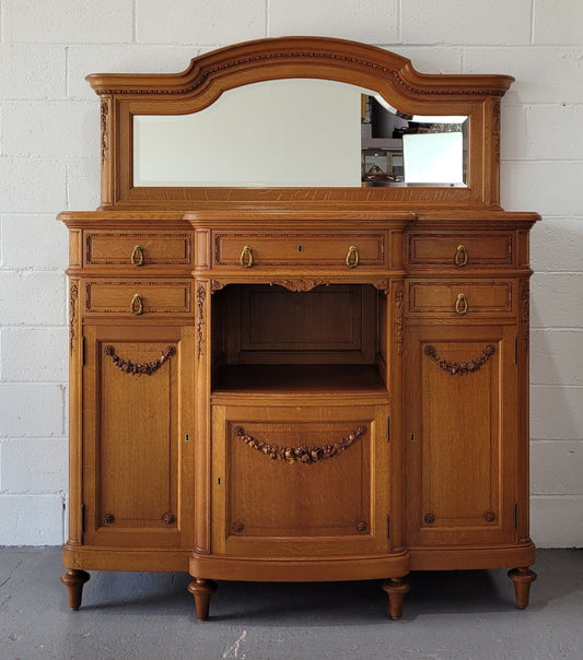 Beautiful French Oak Louis XVI Style nicely carved sideboard with a lovely parquetry top and mirror. It has five drawers and three cupboards for all your storage needs. In good original detailed condition.