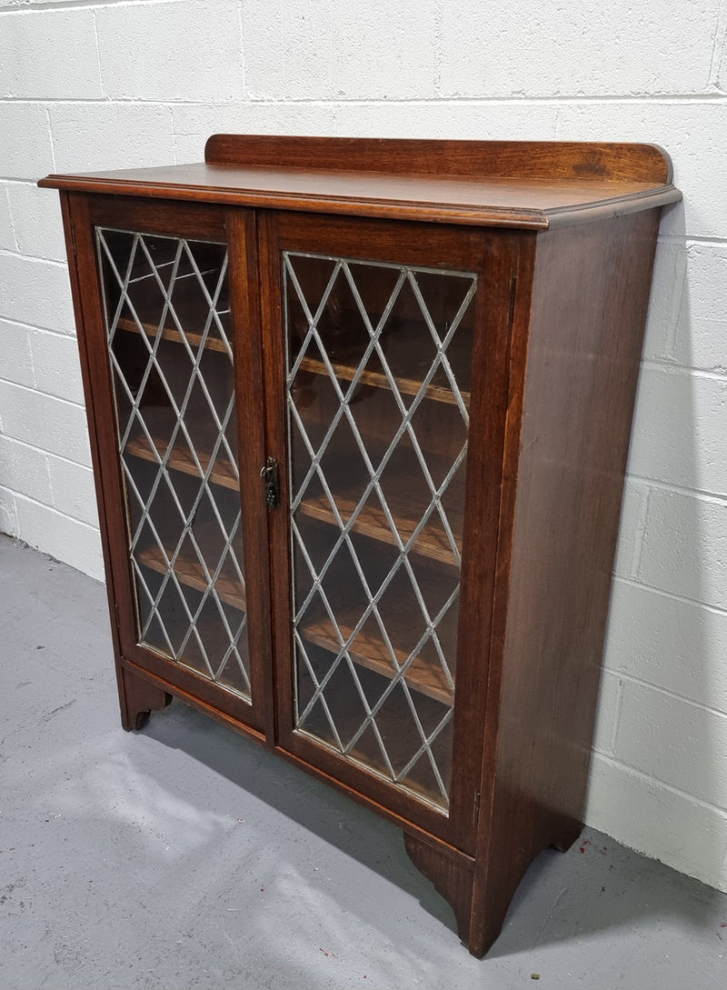 Lovely leadlight two door Oak bookcase/display cabinet with four wooden shelves. It is in good original detailed condition.