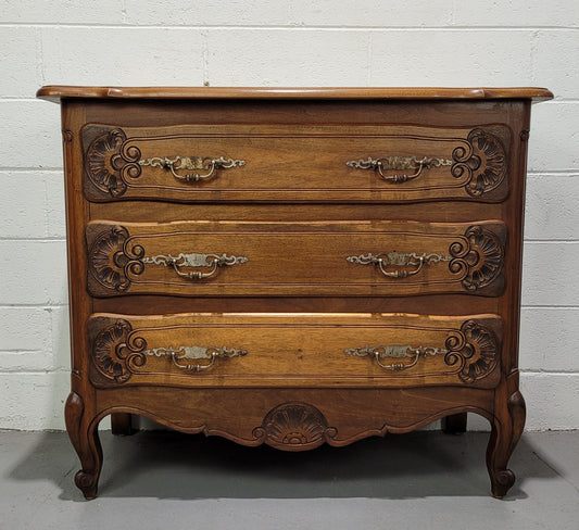 A French Walnut carved three drawer commode with lovely handles and in good original detailed condition.