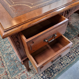 Substantial French Louis XVI style Oak partners desk. It has a beautiful leather top, two drawers on either side and decorative carvings throughout. Sourced from France and in good original detailed condition.
