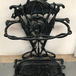 A black cast iron umbrella stand displaying a horse in the middle with four dogs on the side. In good original condition.