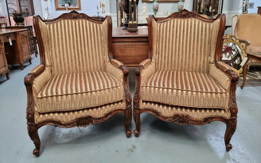 Beautiful pair of Walnut French-style newly upholstered wingback armchairs. They are in very good original detailed condition.